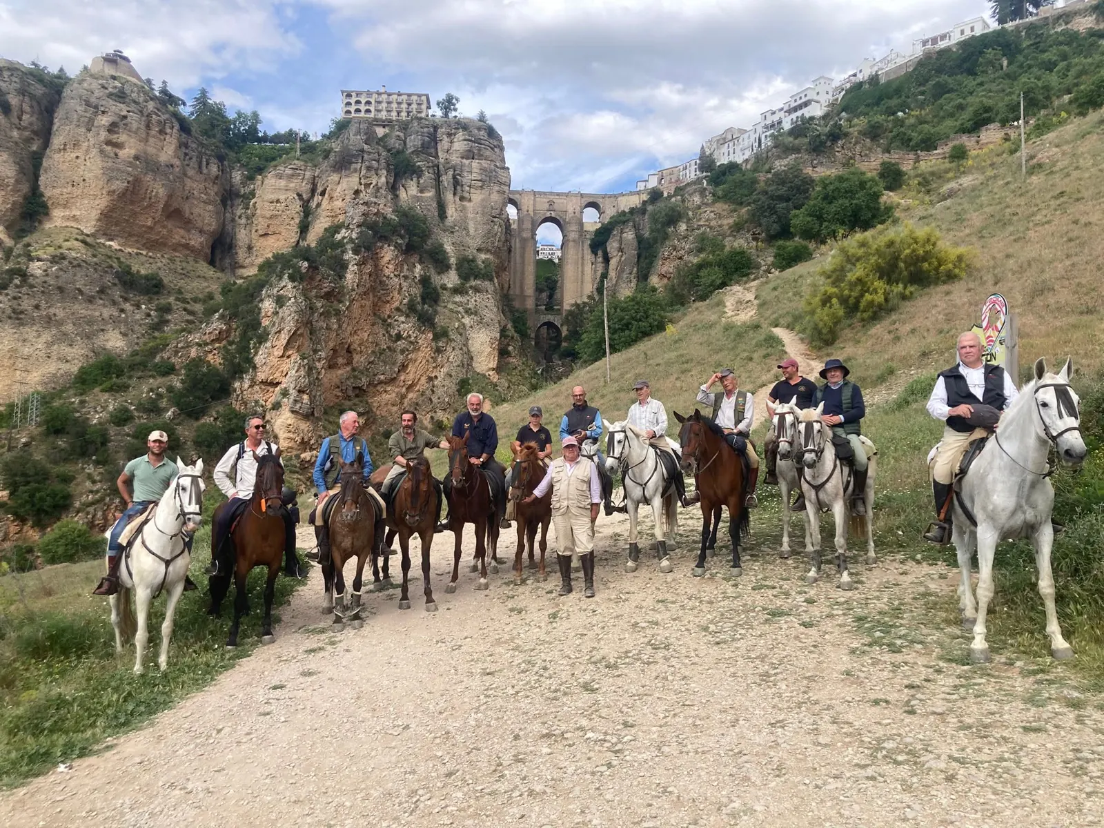 Grupo de jinetes a caballo en el camino bajo el Puente Nuevo de Ronda